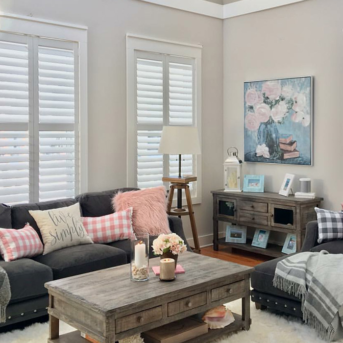 White rear mount tilt shutters in a white and pink style living room.
