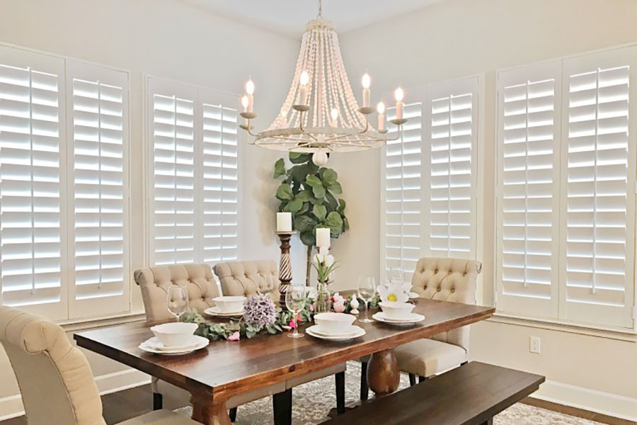 White Polywood shutters on large dining room windows.