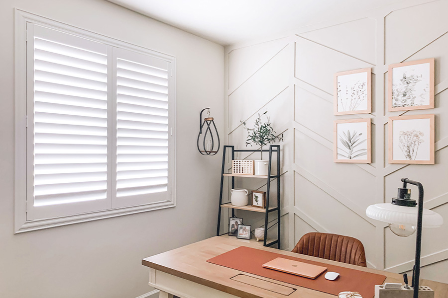 White and off-white farmhouse style office with natural light from polywood shutters.
